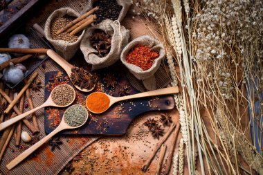 Renkli çeşitli baharat ve otlar doğal doku tahta kaşık içinde ahşap plaka yandı.