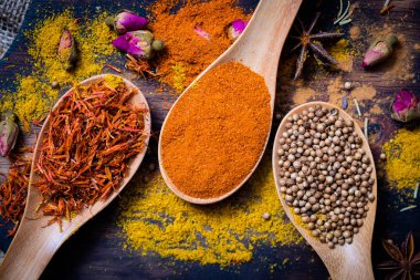 Renkli çeşitli baharatlar ve otlar doğal doku tahta kaşık ahşap plaka yandı.