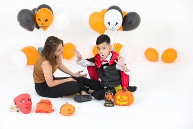 Oda beyaz arka plan üzerinde izole balonlarla dolu korkunç dracula bir Cadılar Bayramı cosplay stüdyo çekim Asya Aile Anne yardım çocuk kostüm giymiş.