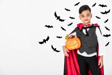 Küçük Asya çocuk jack'O kabak siyah gölge yarasa kesme ile beyaz arka planda tutan Drakula kostümü elbiseli. Cadılar Bayramı komik aktivite ve dekorasyon konsepti.