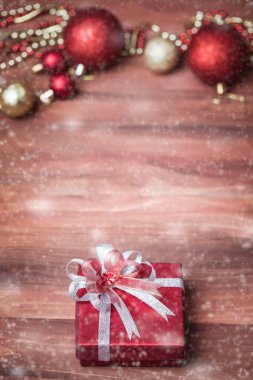 Bir güzel kırmızı hediye kutusu ahşap tahta üzerinde kenar ile Noel ve yeni yıl süsleri, odak yapay kar dışında yumuşak blure düşmek, kopya alanı.