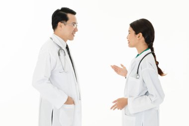 İki Asyalı Doktor aşınma Tekdüzen stetoskop omuz üzerinde beyaz arka planda izole tartışma sağlık hizmeti çalışması.