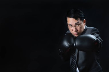 Belgili tanımlık kazanan ve takım başarılı olmak için Asya adam resmi takım elbise ve boks eldivenleri hazır ve kendine güvenen onun hedef başarı için savaşmaya. Rekabet, yılın, en iyi şampiyonu meydan iş kavramı.