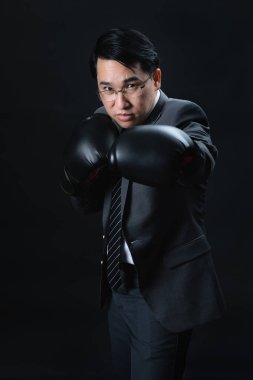 Belgili tanımlık kazanan ve takım başarılı olmak için Asya adam resmi takım elbise ve boks eldivenleri hazır ve kendine güvenen onun hedef başarı için savaşmaya. Rekabet, yılın, en iyi şampiyonu meydan iş kavramı.