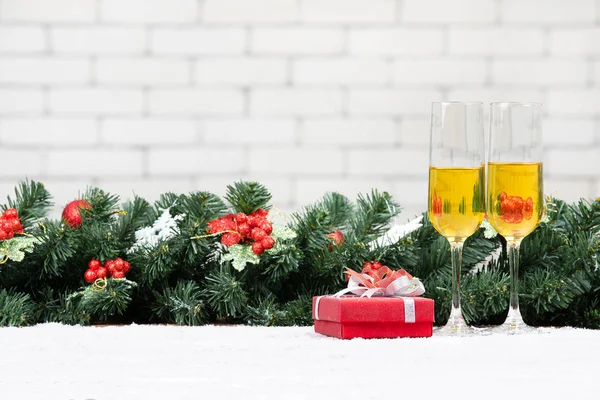 Два Бокала Шампанского Рядом Красной Подарочной Коробкой Снежном Столе Украшают — стоковое фото