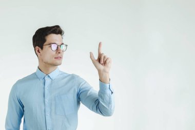 Genç yenilikçi office adam kendinden emin ve ağırbaşlı işaret parmağı yukarıya, portre beyaz arka plan üzerinde izole..