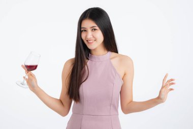 Pembe elbiseli çekici genç Asyalı kadın ona içki holding ve eğlenceli mutlu parti, portre renkli festival balonlu beyaz arka plan üzerinde.