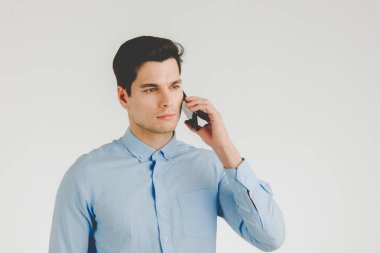Genç hipster adam kendinden emin ve ciddi iş iş, beyaz arka plan üzerinde izole portre için telefonda konuşuyor.