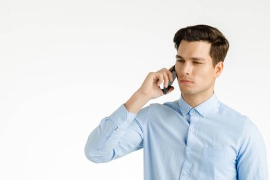 Genç hipster adam kendinden emin ve ciddi iş iş, beyaz arka plan üzerinde izole portre için telefonda konuşuyor.