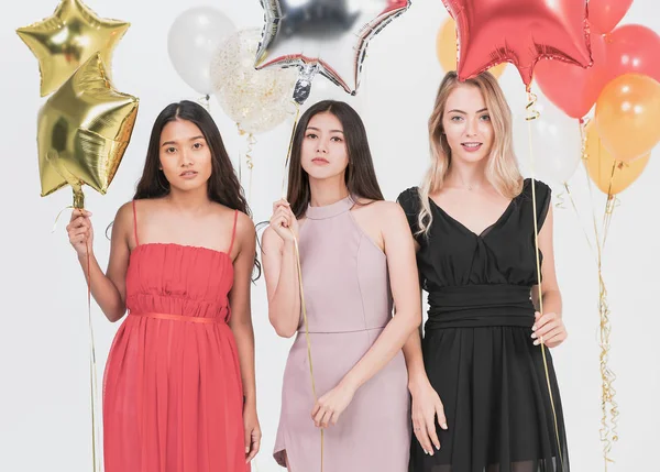 Diversity of young happy women have fun together at party, white background and colorful festive balloons.