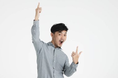 Genç, siyah saçlı gri tişörtlü, el Asya adam portresi varoluş studio onun kafa, iri gözlü, açık geniş ağız heyecan ifade üzerinde beyaz arka plan izole kamera için düz arıyorsunuz