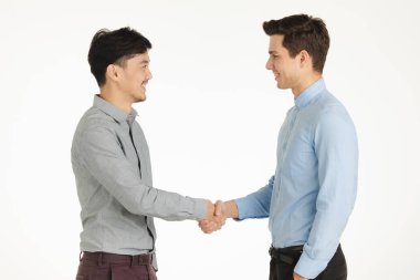 Varoluş stüdyo portre iş el sıkışma poz, iki genç adamın birbirlerine dostu şekilde gülümseyen izole beyaz arka plan üzerinde duran