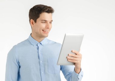 Genç hipster adam, iş çalışmaları, beyaz arka plan üzerinde izole portre için tablet kullanırken emin mutlu gülümseme.