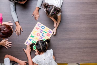 Asyalı öğretmen düz yatıyordu atış renkli alfabe ahşap bloklar Asya öğrenci sınıf birlikte, konsepti ile oynamak.