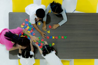 Çocuklar ve öğretmenler sınıfta renkli oyuncaklar oynuyorlar. Okul boş zamanlarında mutlu ve eğlenceli öğrenme, beyin geliştirme aktiviteleri kavramı.