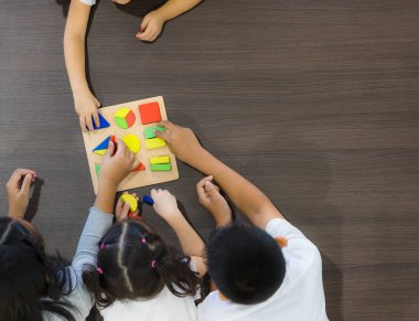 Düz çekim Asyalı öğretmen oyun geometri blok oyuncak Asya öğrenci sınıf birlikte, konsepti ile yatıyordu.