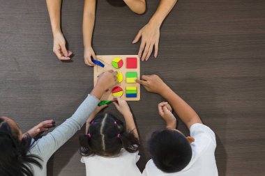 Düz çekim Asyalı öğretmen oyun geometri blok oyuncak Asya öğrenci sınıf birlikte, konsepti ile yatıyordu.