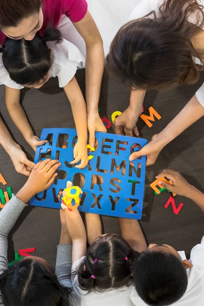 Shot Płasko Świeckich Azjatyckich Nauczycieli Zagraj Kolorowe Zabawki Puzzle Alfabet — Zdjęcie stockowe
