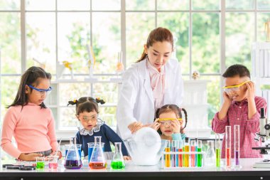 Fen bilgisi öğretmeni öğretmek kimyasallar, renkli tüp ve laboratuvar Oda tabloda, kavram mikroskobunun çalışma laboratuvar odasında için hakkında Asya öğrenciler.