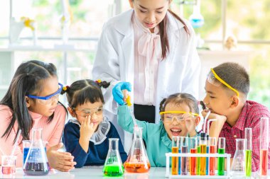 Fen bilgisi öğretmeni öğretmek öğretmen damla laboratuvar odasında Asya öğrenciler bir şey turuncu tüp, renkli tüp ve tablo, laboratuvar Oda çalışmada için kavram mikroskobunun içine.