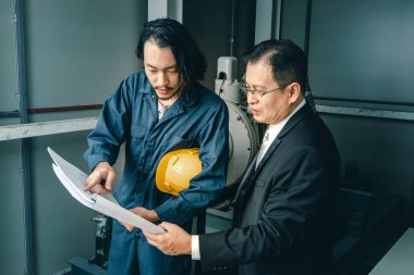 Asya çift mühendis ve genç bir mühendis blueprint görünüm ve birlikte, endüstriyel fabrika mühendisi için kavram tartışmak.