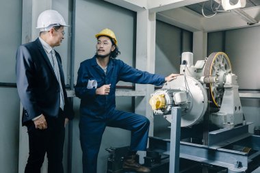 Asya çift mühendis ve birlikte duran genç bir mühendis ve kamera için gülümseme, büyük planı elinde, endüstriyel fabrika mühendisi için kavram tutar.