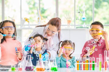 Fen bilgisi öğretmeni ve laboratuvar odasında Asya öğrenciler, onlar kabarcıklar, üfleme renkli tüp ve laboratuvar Oda, kavram için tabloda mikroskobunun laboratuvar içinde çalışma odası.