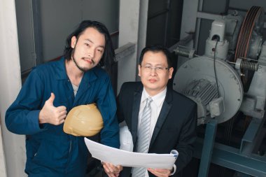 Asya yönetici mühendisi ve genç mühendis planı tutan ve kamera iş bakmak iyi gitti, sanayi fabrikasında mühendis için kavram.