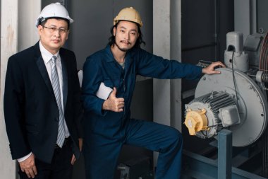 Asya yönetici mühendisi ve genç mühendis planı tutan ve kamera iş bakmak iyi gitti, sanayi fabrikasında mühendis için kavram.