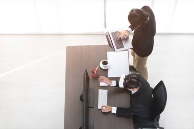 Genç iş adamı, sanal gerçeklik sunumunu izlemek için maske takan orta yaşlı iş adamının yanında defter tutuyor. Vr, yakın gelecekte yaygın olarak kullanılan yeni bir teknolojidir..