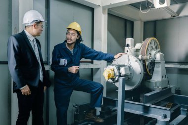 Asya çift mühendis ve birlikte duran genç bir mühendis ve kamera için gülümseme, büyük planı elinde, endüstriyel fabrika mühendisi için kavram tutar.