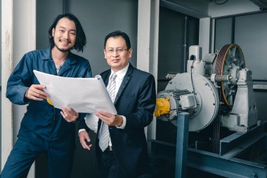 Asya çift mühendis ve genç bir mühendis blueprint görünüm ve birlikte, endüstriyel fabrika mühendisi için kavram tartışmak.