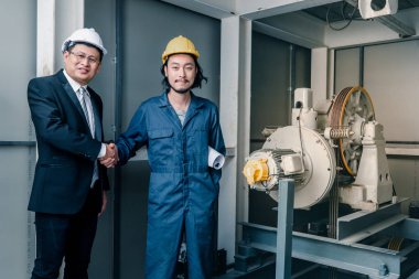 Asya çift mühendis ve birlikte duran genç bir mühendis ve kamera için gülümseme, büyük planı elinde, endüstriyel fabrika mühendisi için kavram tutar.