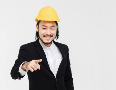 Asyalı mühendis portresi, siyah takım elbiseli, başında sarı kask, ayakta ve nokta öne çıkıyor, arkasında beyaz arka plan.