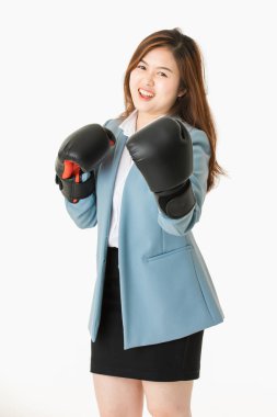 Genç yakın çekim stüdyo portre, güzel, çekici Asyalı bayan, açık mavi iş elbisesi içinde, siyah deri boks eldivenkoymak, eğlenceli mücadele eylem için poz, izole beyaz arka plan üzerinde