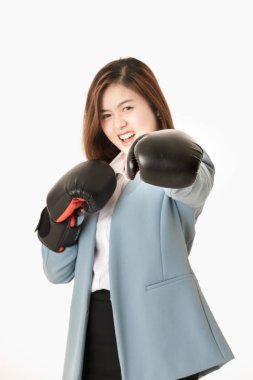 Genç yakın çekim stüdyo portre, güzel, çekici Asyalı bayan, açık mavi iş elbisesi içinde, siyah deri boks eldivenkoymak, eğlenceli mücadele eylem için poz, izole beyaz arka plan üzerinde