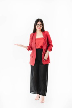 Genç çekici Asyalı kadının tam uzunlukta stüdyo portresi, uzun siyah saçlı, gözlük takan, rahat moda, yüksek topuk, izole beyaz arka plan üzerinde sağ avuç içi gülümseyen