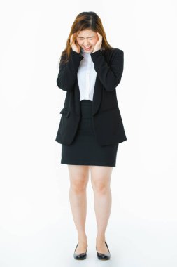 Genç tam uzunlukta stüdyo portre, güzel, çekici Asyalı bayan, iş elbisesi içinde, endişeli yüz, aşağı bakıyor, sinirli yüzüne dokunmak, bir şey hakkında endişe, izole beyaz arka plan üzerinde