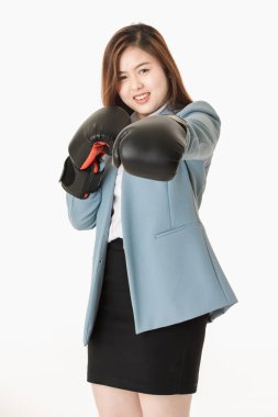 Genç yakın çekim stüdyo portre, güzel, çekici Asyalı bayan, açık mavi iş elbisesi içinde, siyah deri boks eldivenkoymak, eğlenceli mücadele eylem için poz, izole beyaz arka plan üzerinde