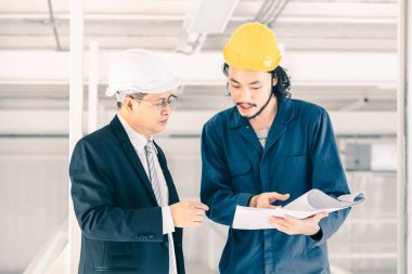 Genç Asyalı mühendis endüstriyel fabrikada yönetici mühendis ile tokalaşıyor, taslak genç mühendis eli, patron konsepti endüstriyel fabrikayı ziyarete geliyor.