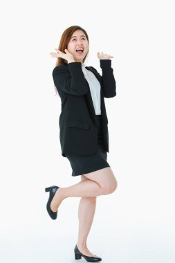 Iş elbisesi genç, güzel, çekici Asyalı bayan tam uzunlukta stüdyo portre, uzun saç neşeyle gülümseyen, poz, yayılmış eller, yukarı bakıyor, izole beyaz arka plan üzerinde