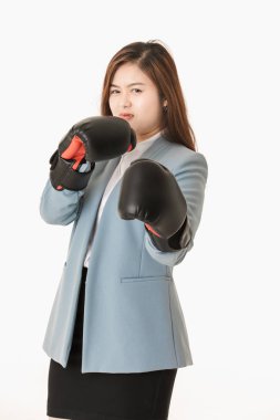 Genç yakın çekim stüdyo portre, güzel, çekici Asyalı bayan, açık mavi iş elbisesi içinde, siyah deri boks eldivenkoymak, eğlenceli mücadele eylem için poz, izole beyaz arka plan üzerinde