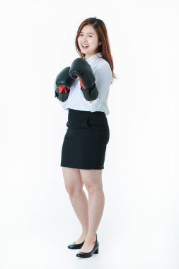 Genç yarım uzunlukta stüdyo portre, güzel, çekici Asyalı bayan, beyaz gömlek ve siyah etek, siyah deri boks eldivenleri ile, eğlenceli alay mücadele eylem, izole beyaz arka plan üzerinde