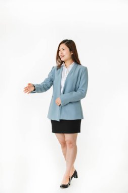 Asya genç işkadını portre açık bir el için el sıkışma stüdyo hazır ile gülümseyen kıyafetli akıllı beyaz arka plan üzerinde ateş.