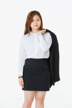 Beyaz gömlekli genç, güzel, çekici Asyalı bayanın tam uzunlukta stüdyo portresi, bir kolunda iş elbisesi, kalçada el, profesyonel poz, kameraya bakma, izole beyaz arka plan üzerine