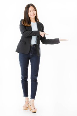 Genç, güzel, Asyalı bayan, uzun siyah saçlı, akıllı rahat, ayakta, basılı ve sol tarafta görünmez ürünleri işaret, reklam için kopya alanı, izole beyaz arka plan üzerinde