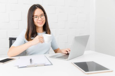 Genç, güzel, Asya mimar, giyen gözlük Oda kalem elinde, Toplantı inşaat sahasında alarak not notepad, defter ile üzerinde çalışma tablet ve smartphone ve kahve Kupası arka plan