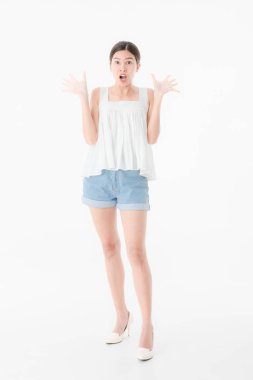 Tam uzunlukta, rahat yaz giysileri genç güzel, çekici Asyalı kadın portresi, denim şort ve gevşek tank üst, yüksek topuk, ayakta, sürpriz ifade poz, izole beyaz arka plan üzerinde