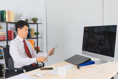 Orta portresi yaşlı, onun başlangıç office, office arka plan ile onun başarı ile mutlu çalışan yakışıklı, Asya, işadamı, koyu kırmızı kravat, Beyaz gömlekli