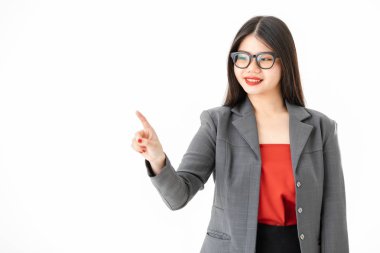 Genç, çekici Asyalı bir kadının yakın çekim portresi, uzun siyah saçlı, gözlüklü, sıradan bir şekilde gülümseyen, sanki izole edilmiş beyaz arka planda görünmez bir ekrana dokunuyormuş gibi.